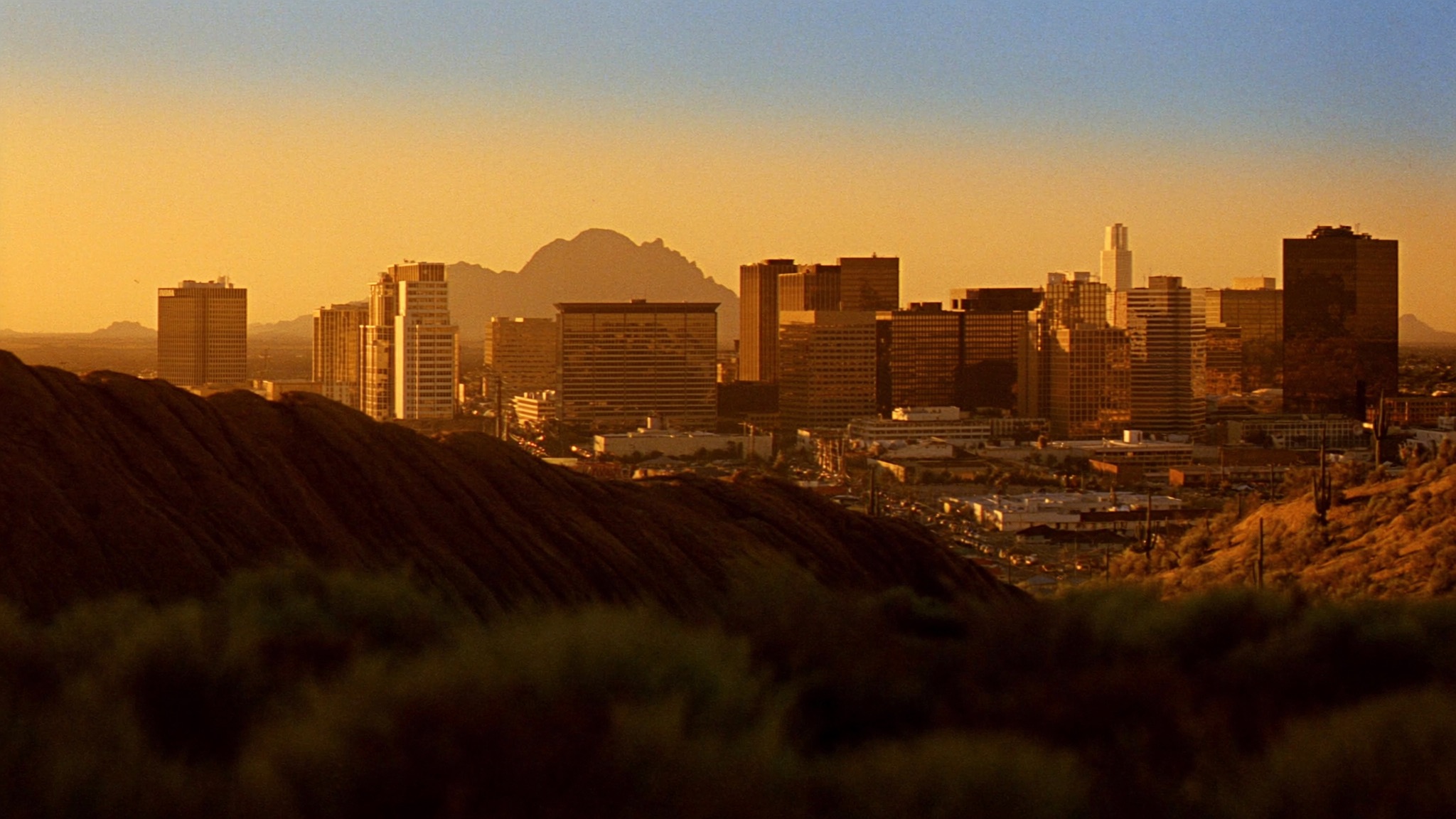Phoenix, Arizona skyline at golden hour with saguaro desert foreground